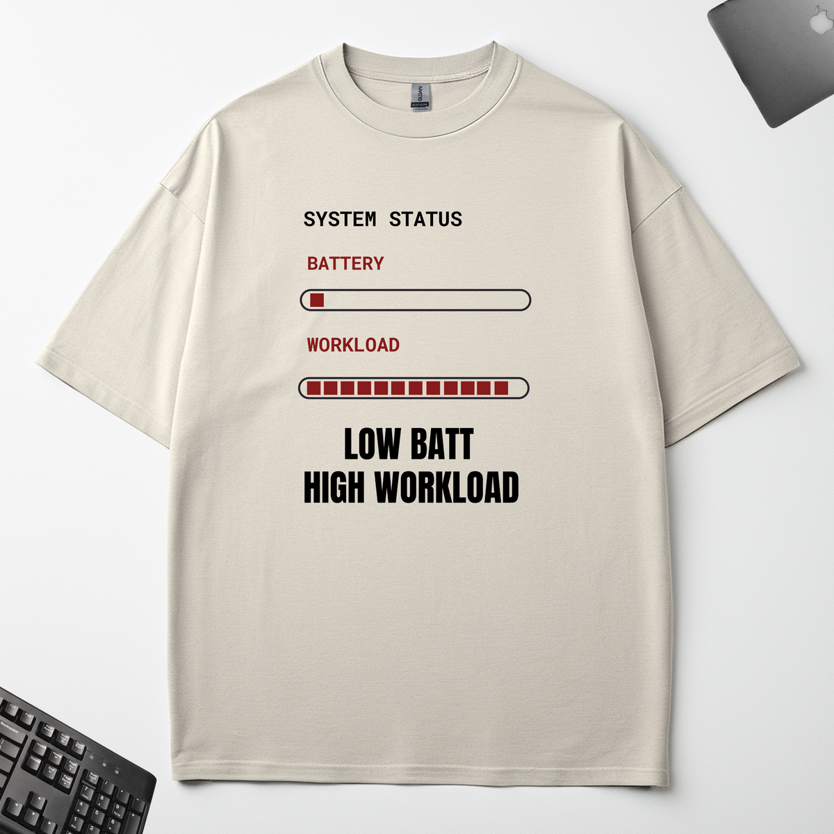 Low Battery High Workload off-white oversized t-shirt flat lay on an office desk