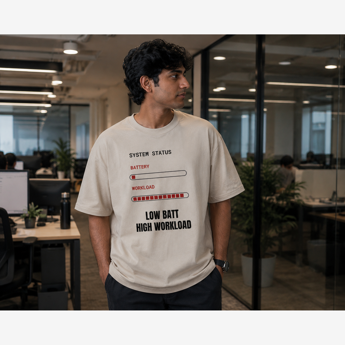 Man wearing Low Battery High Workload oversized t-shirt in a modern office